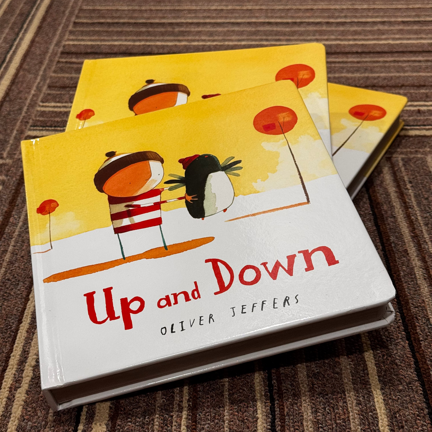 Children's book titled 'Up and Down' by Oliver Jeffers on a textured surface