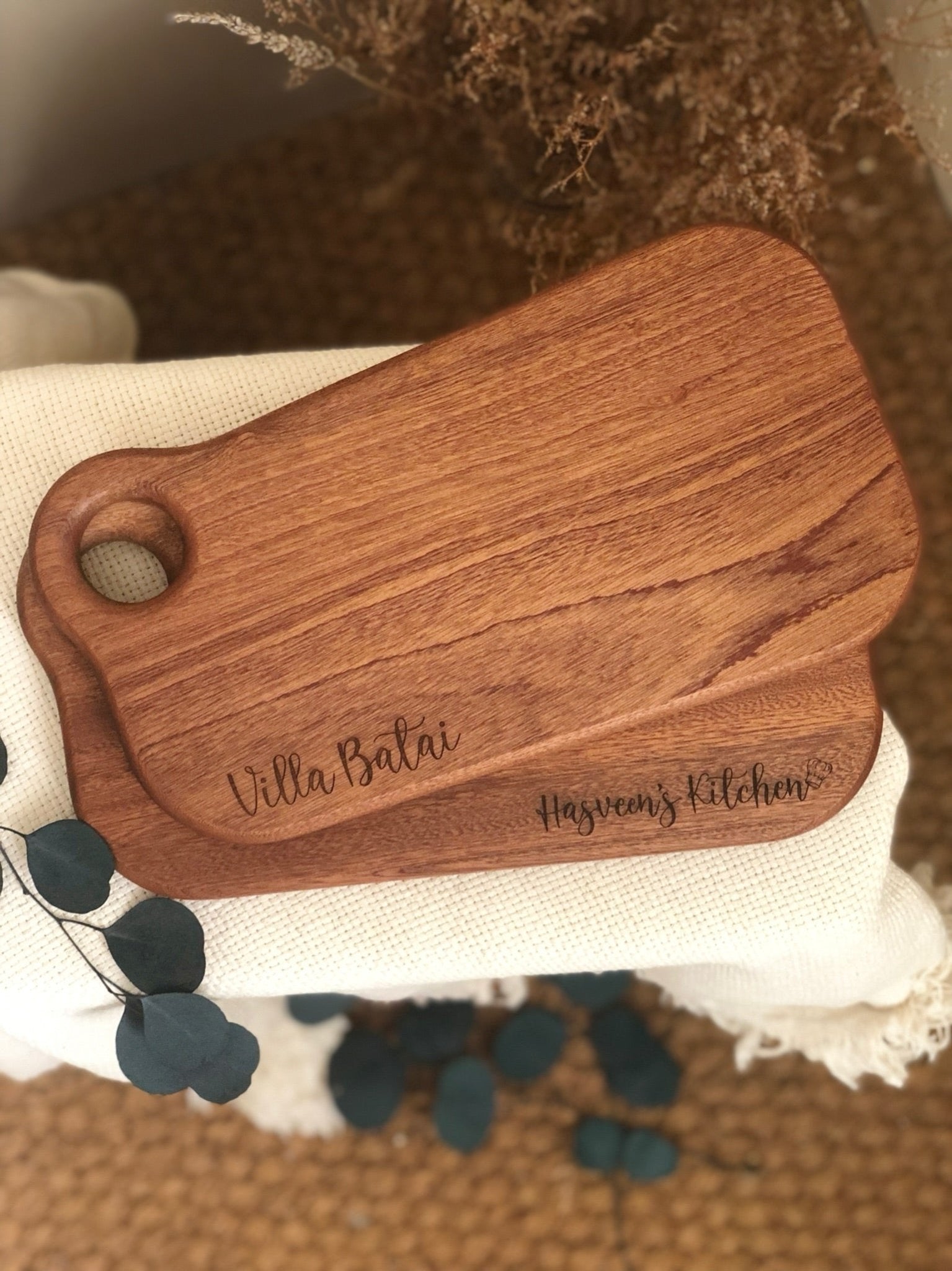 Engraved serving board made from ebony wood with personalized name as housewarming gift
